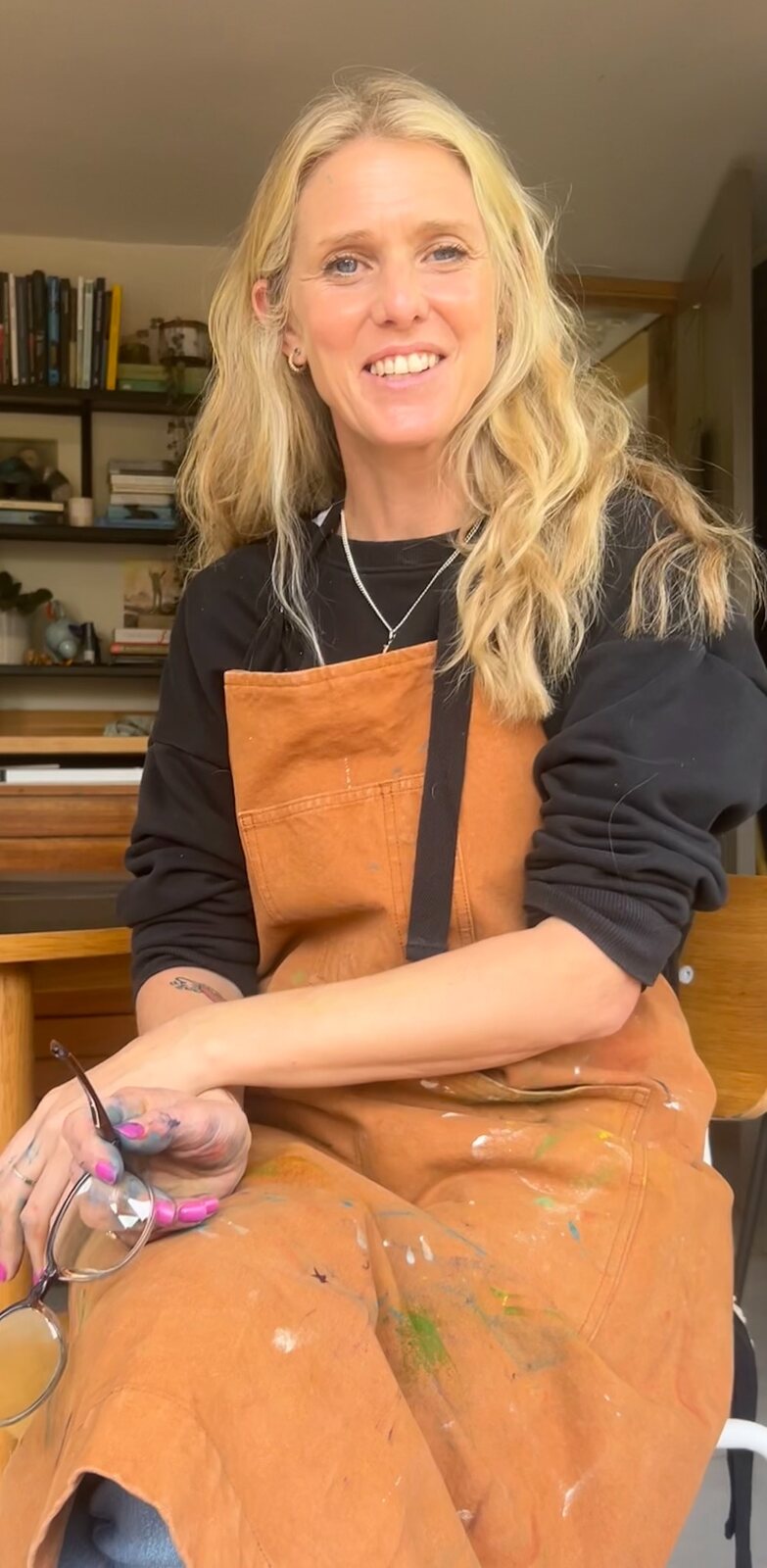 Rebecca Cox in her studio wearing a paint-marked artist’s apron