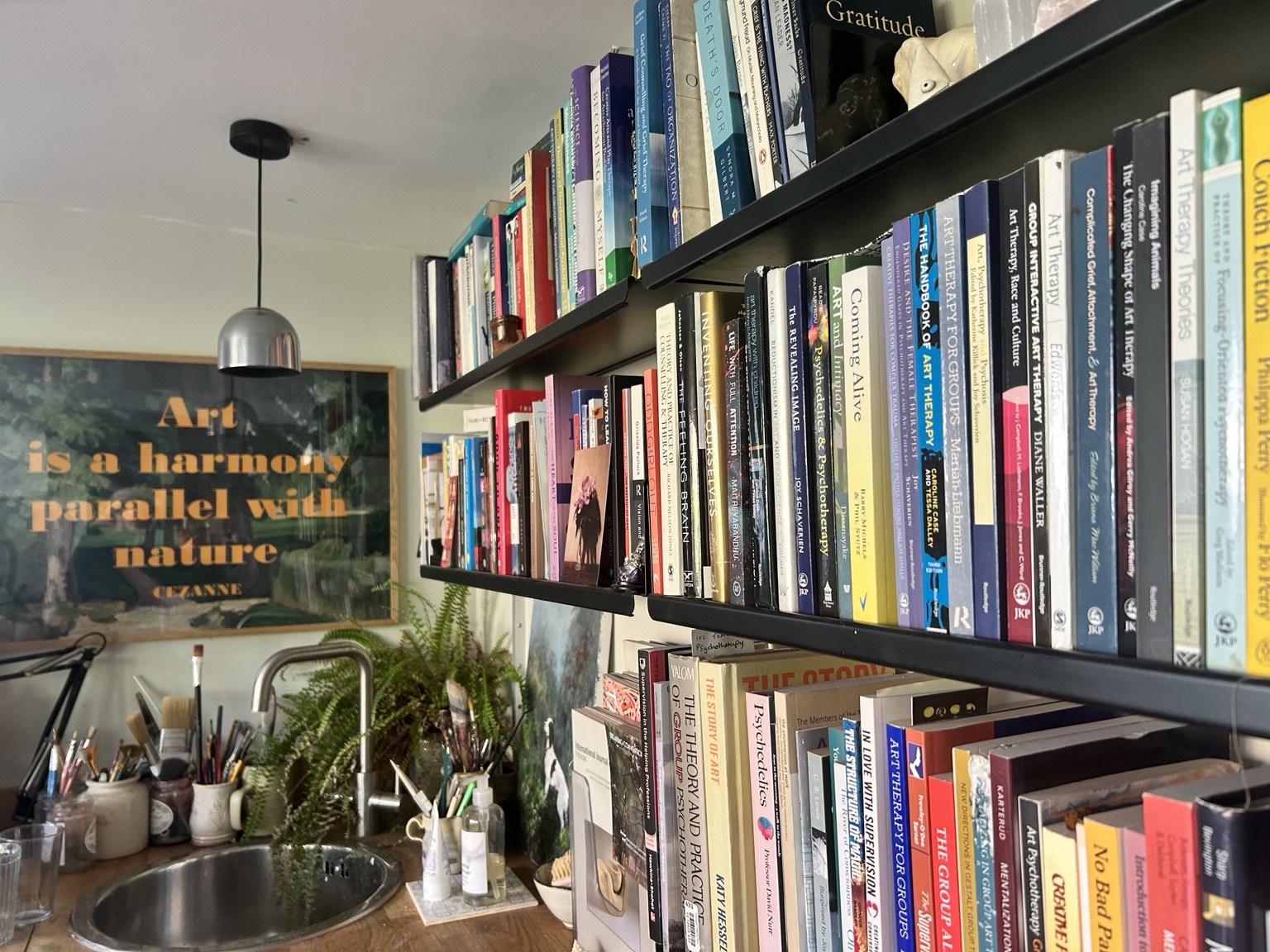 Therapy and art books, art materials and plants in Rebecca’s working studio